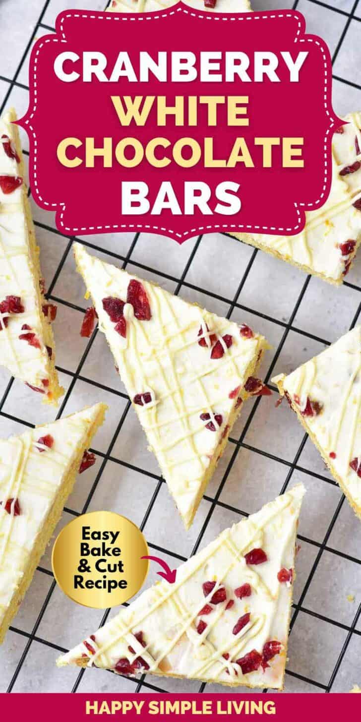 Sliced cranberry white chocolate bars arranged on a cooling rack. Each triangular piece has a white chocolate drizzle and cranberry bits. Text reads Cranberry White Chocolate Bars and Easy Bake & Cut Recipe.