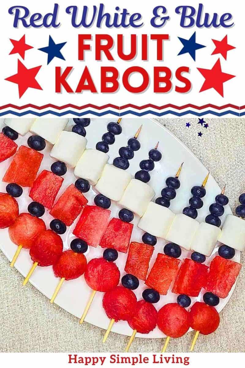Red white and blue fruit kabobs on a white serving platter.