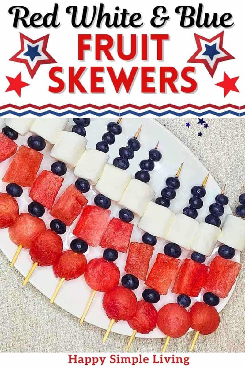 A white platter of red white and blue fruit skewers.